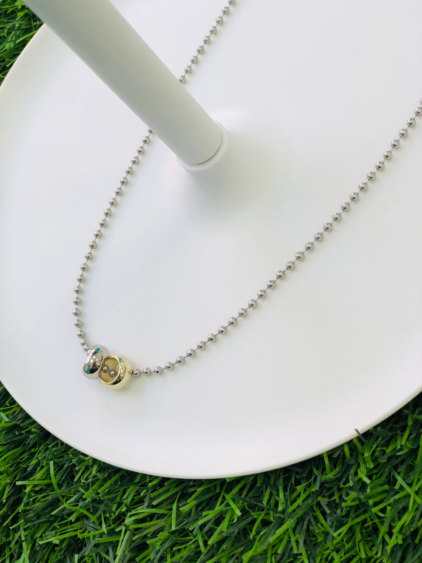 A short necklace with two rings, gold and silver
