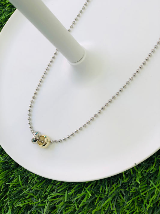 A short necklace with two rings, gold and silver