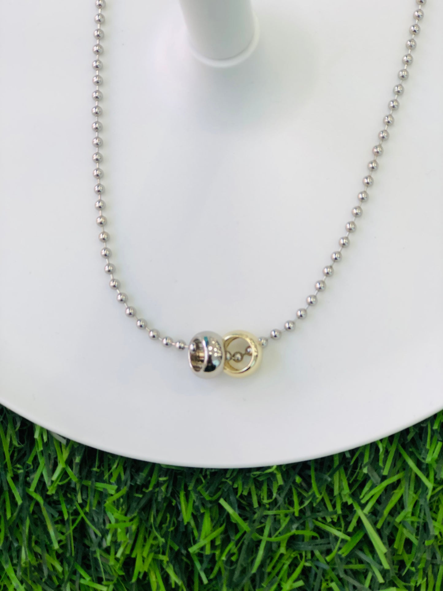 A short necklace with two rings, gold and silver