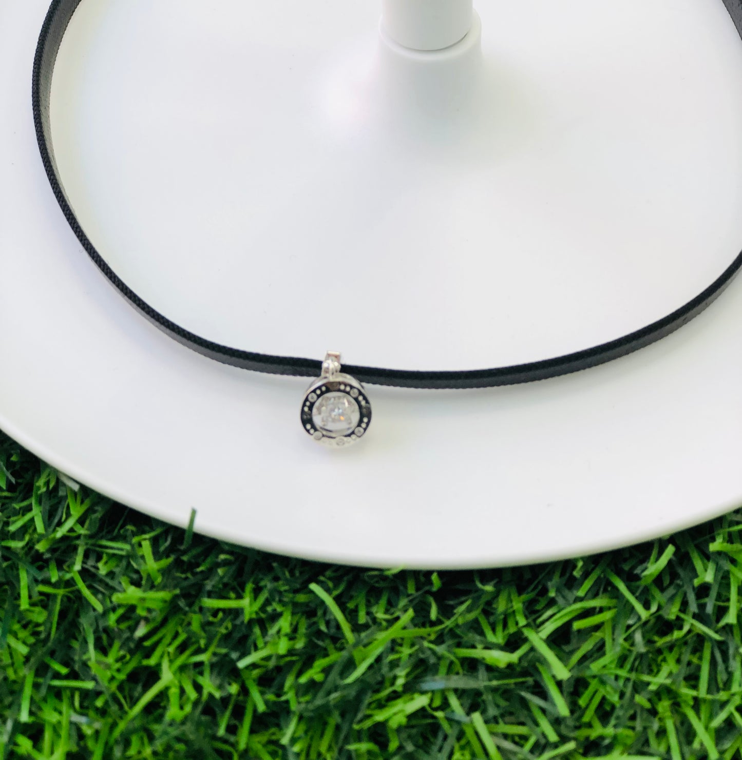 Short black leather necklace with a shaped medallion