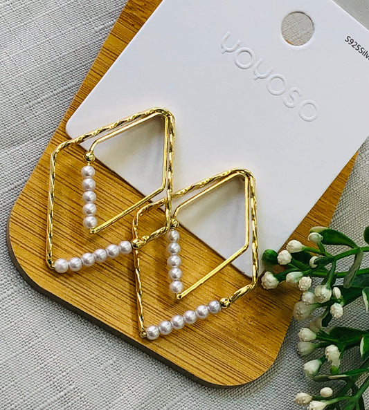 Golden diamond-shaped earring with white beads