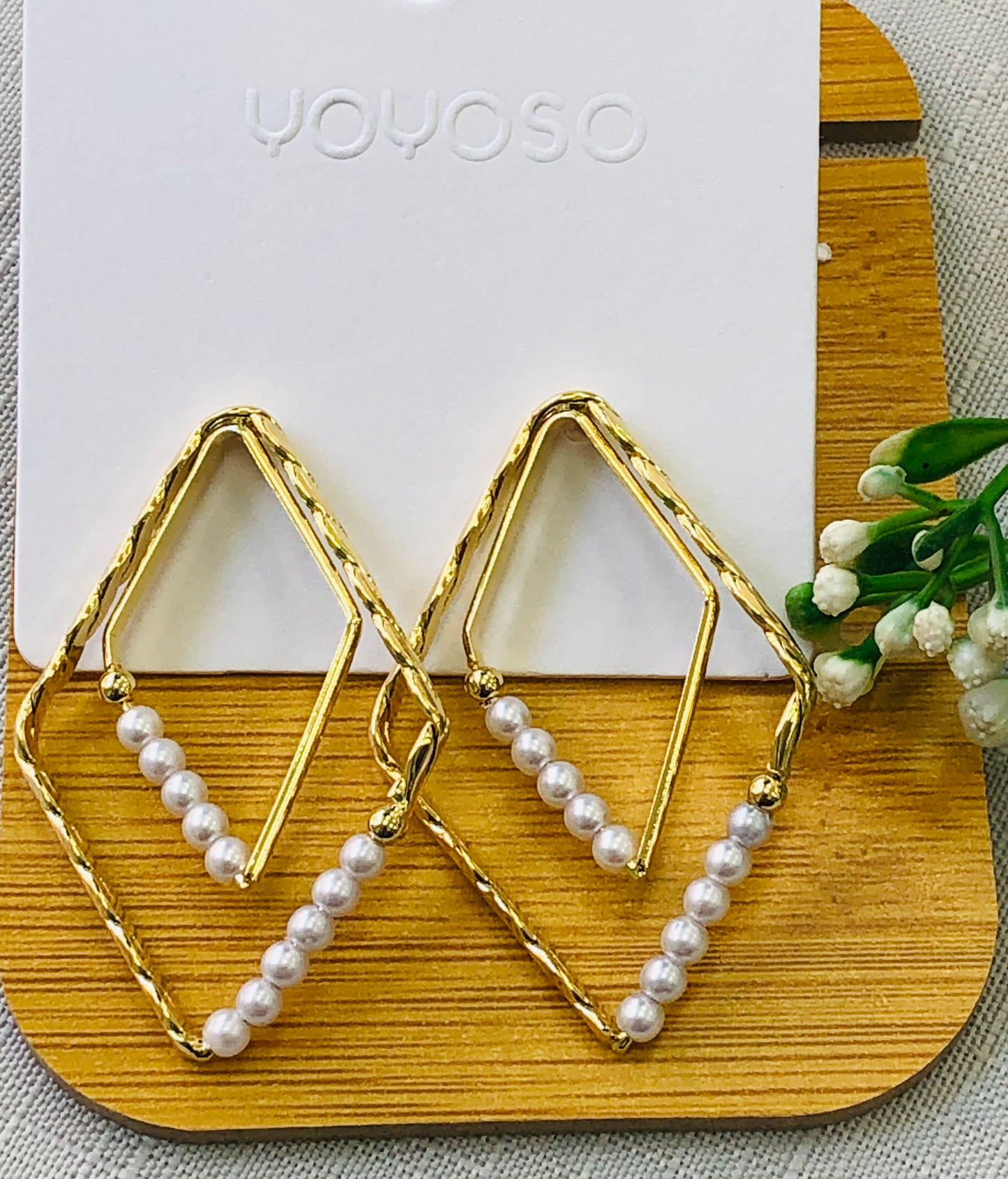 Golden diamond-shaped earring with white beads