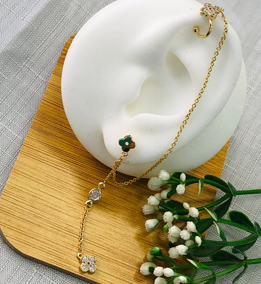 Long gold earrings wrapped around a rose