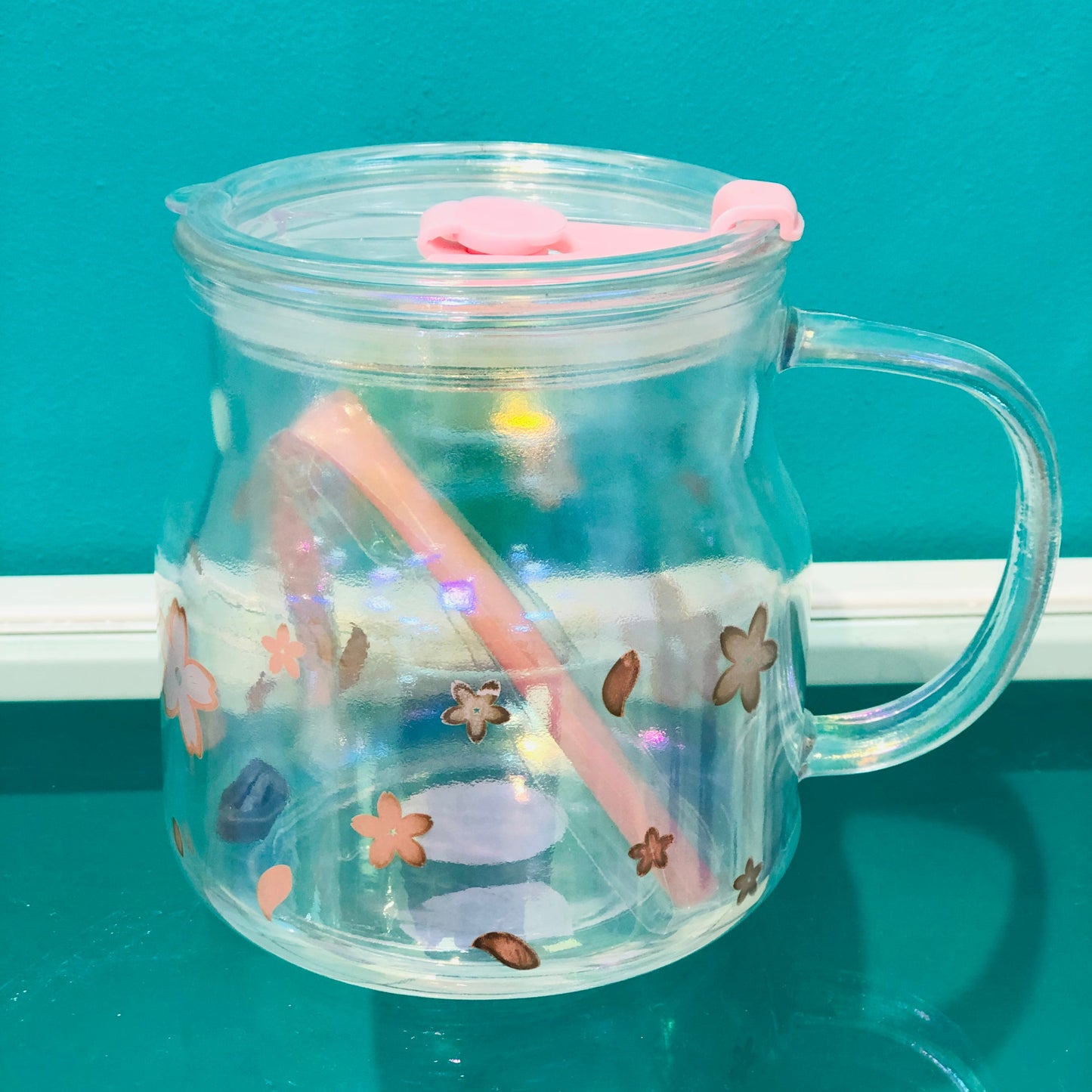 Clear glass cup with straw and graphic lid