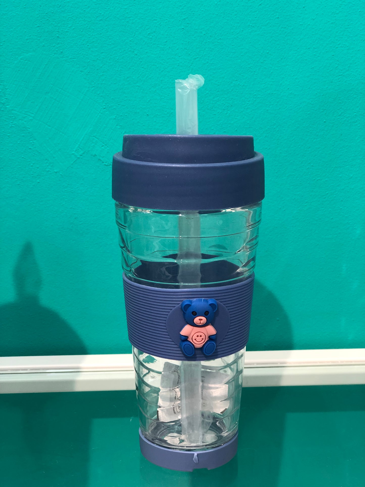 Clear glass cup with silicone base and straw