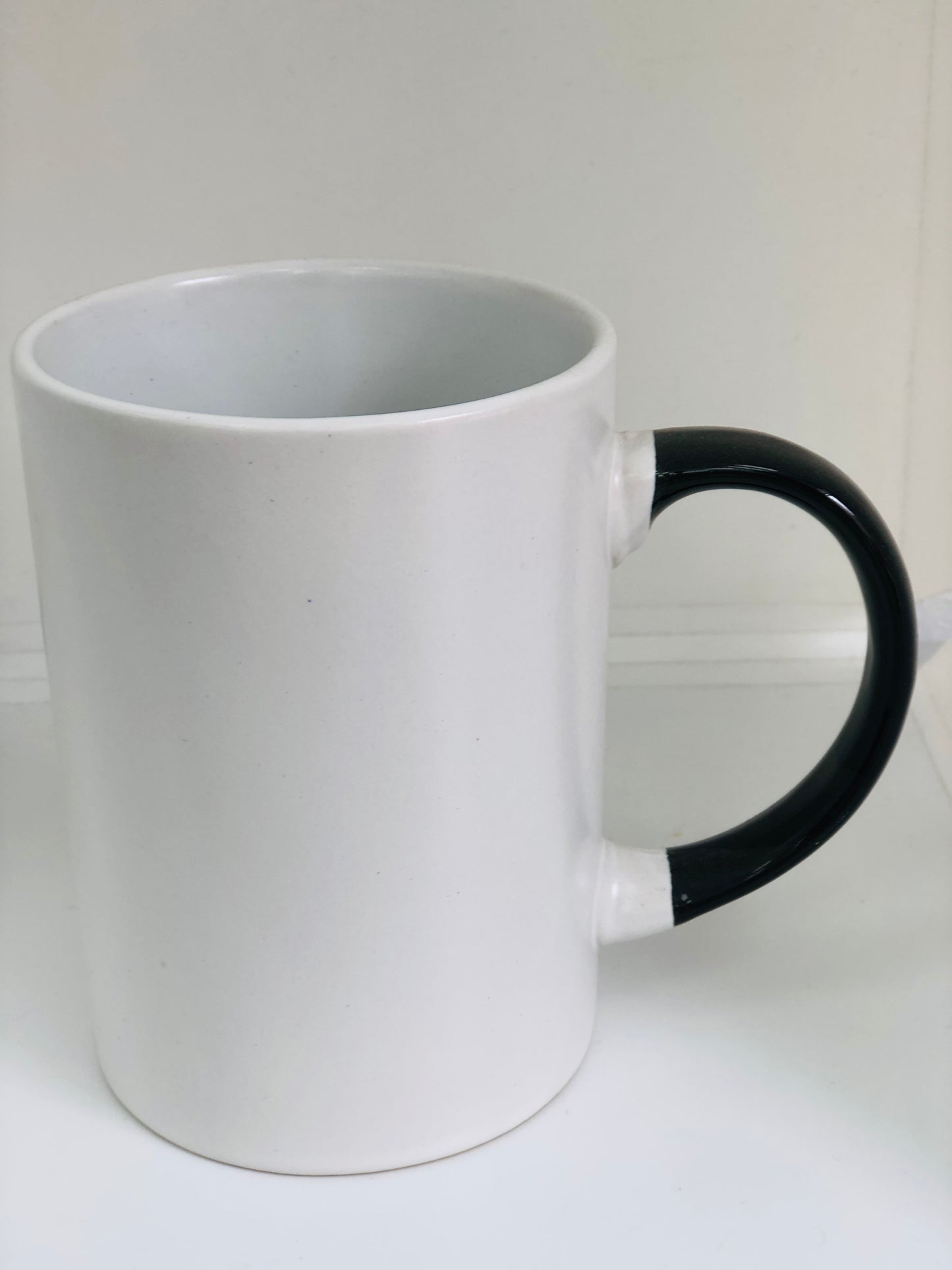 White ceramic mug with black handle