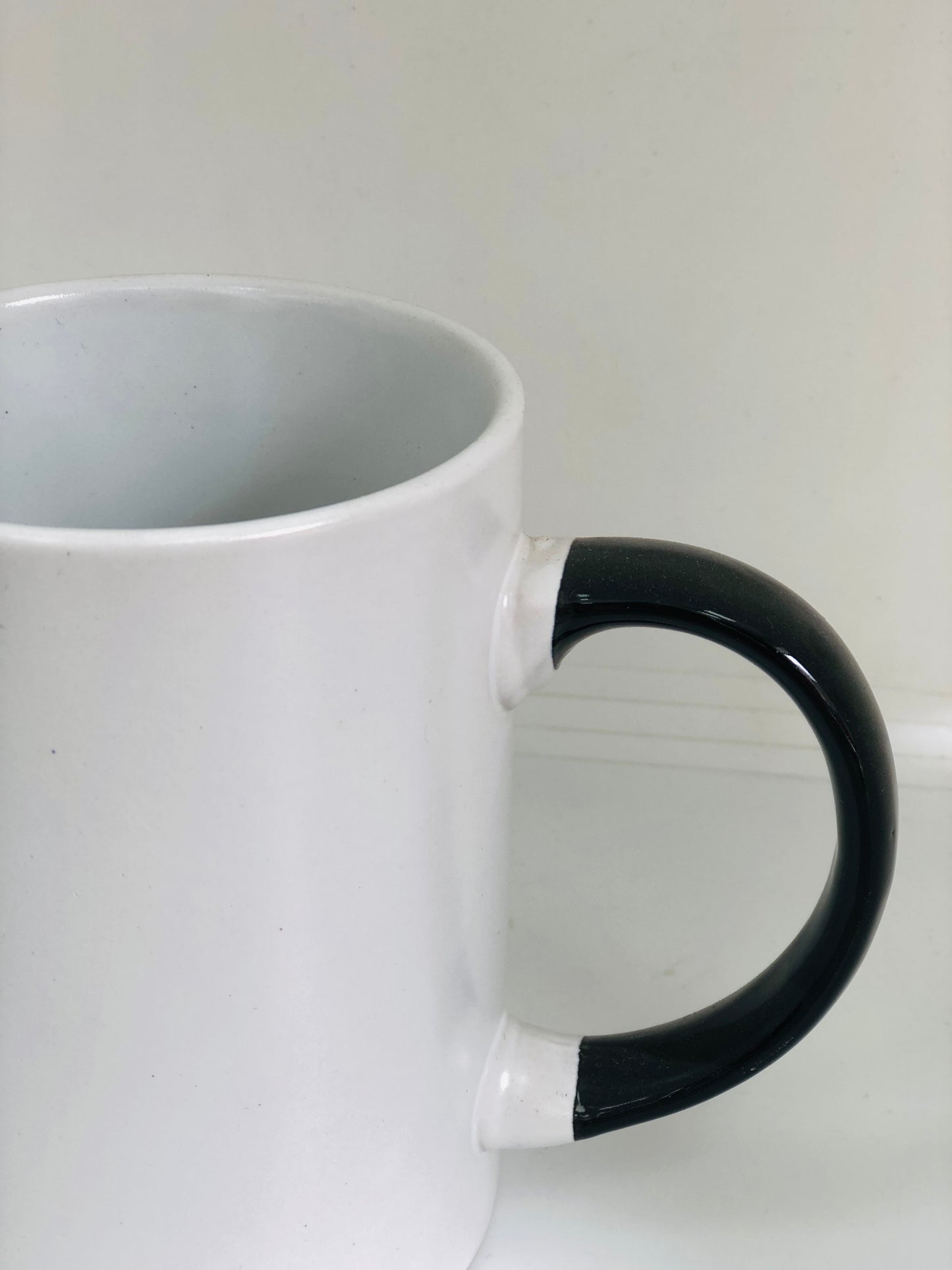 White ceramic mug with black handle